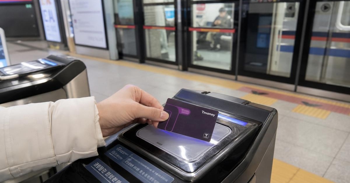 Photorealistic close-up of a Tmoney card being tapped at a Seoul subway fare gate